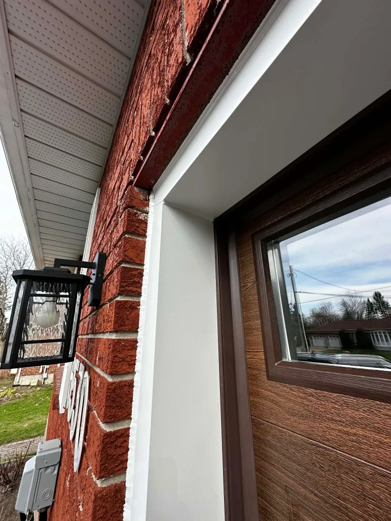 White aluminum garage door jamb capping installed on red brick home in Ottawa