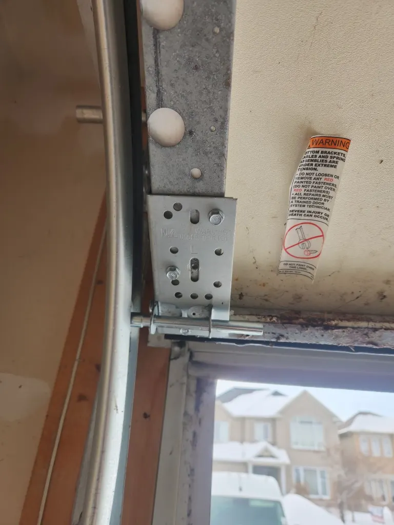 Garage door bottom bracket and roller on a Barrhaven door during cable repair