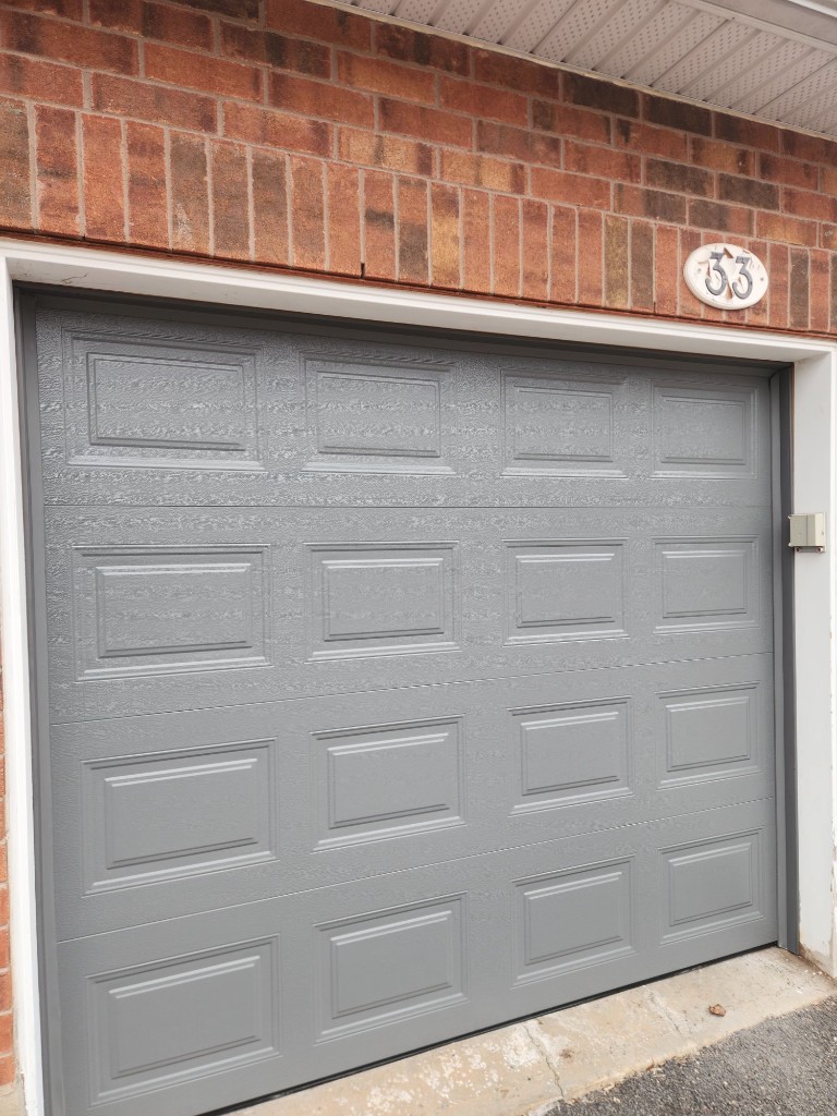 New insulated charcoal raised-panel garage door installation in Kanata, Ottawa