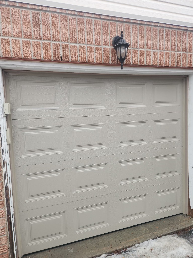 Beige insulated garage door installation in Ottawa