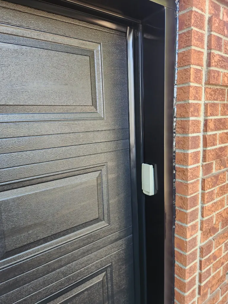 Garage door frame corner with weather seal and trim detail in Greely