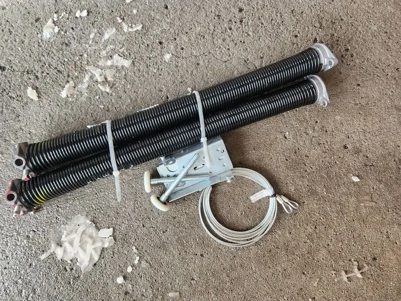 Close-up of torsion springs, cables, and hardware replaced on an Ottawa garage door