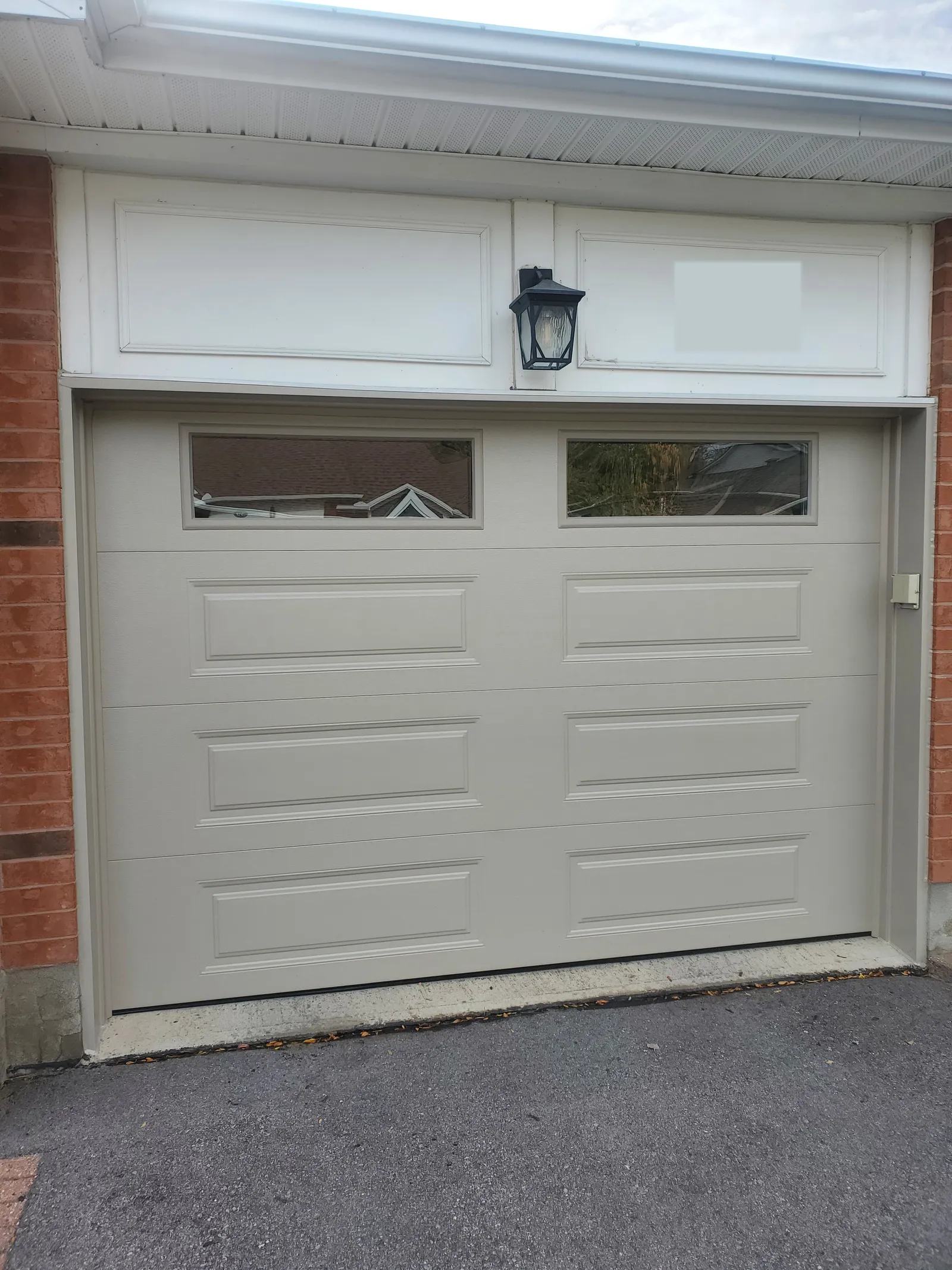 New almond single insulated garage door with long panels and two windows in Kanata